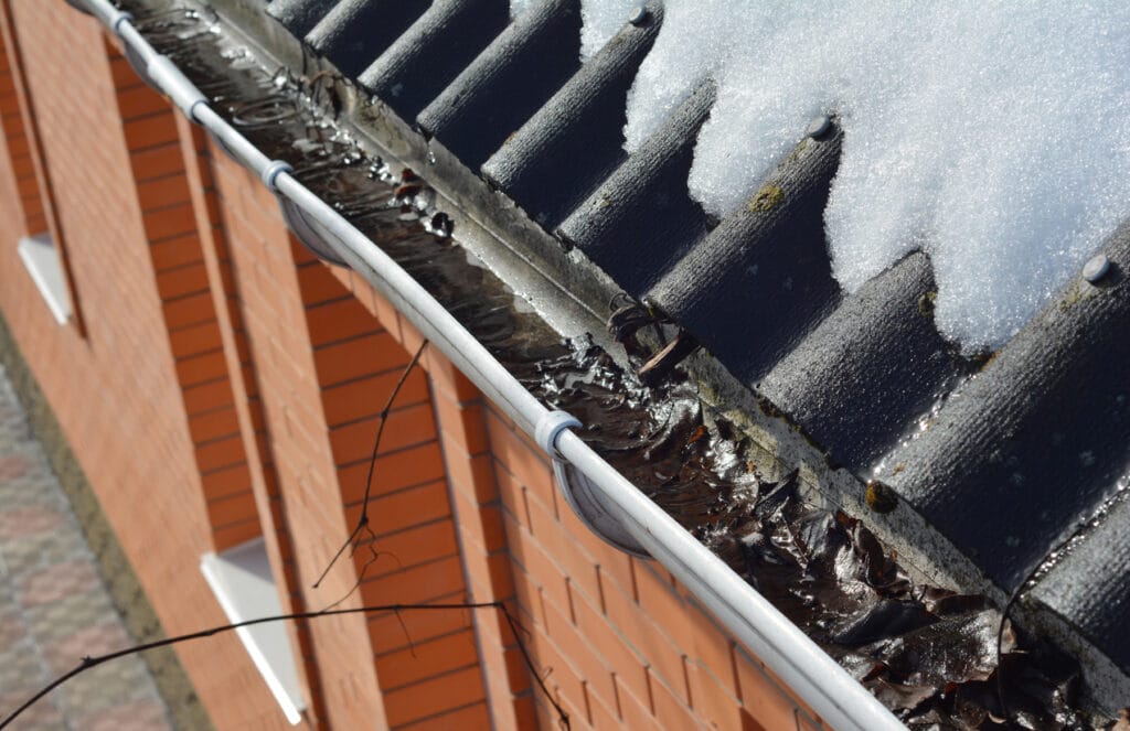 Clogged gutters that can lead to water backup and ice dams, ultimately damaging roofs.